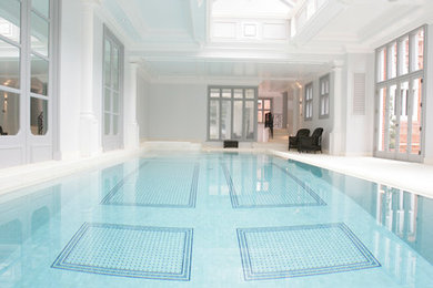 Ejemplo de casa de la piscina y piscina rectangular con suelo de baldosas