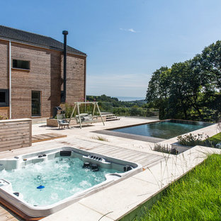 Inspiration for a farmhouse back rectangular infinity swimming pool in Devon with a hot tub.