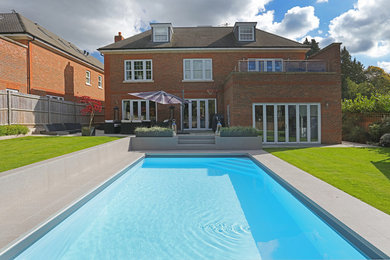 Design ideas for a medium sized modern back rectangular swimming pool in Berkshire with tiled flooring.