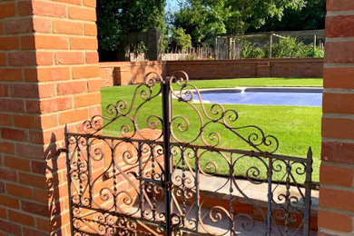 This is an example of a medium sized traditional back rectangular lengths swimming pool in Hampshire with brick paving.