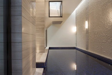 Design ideas for a small contemporary indoor rectangular natural swimming pool in London with natural stone paving.