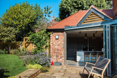 Inspiration for a large traditional back terrace in Cheshire with an outdoor kitchen and a pergola.