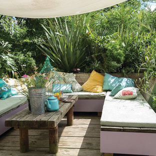 Ispirazione per una terrazza boho chic dietro casa con un giardino in vaso e un parasole