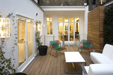 ロンドンにある高級な広いコンテンポラリースタイルのおしゃれな裏庭のデッキ (壁面緑化、日よけなし) の写真