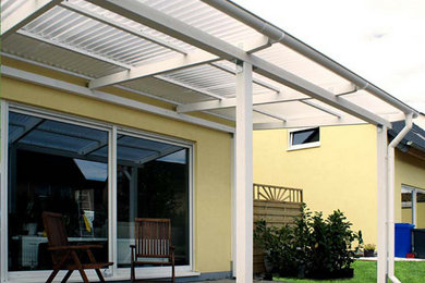 This is an example of a medium sized contemporary back terrace in Frankfurt with a roof extension.