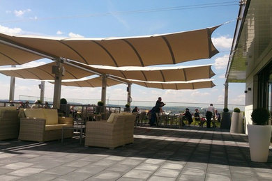Ispirazione per una grande terrazza minimal con un parasole