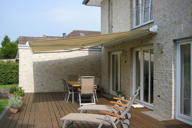 Modelo de terraza tradicional de tamaño medio en patio trasero con toldo
