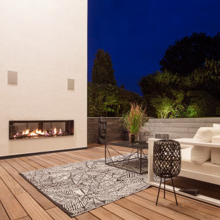 Deck - large contemporary backyard deck idea in Dortmund with a fireplace and no cover