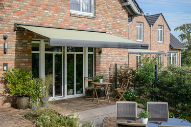 Photo of a classic back terrace in Essen with an awning.