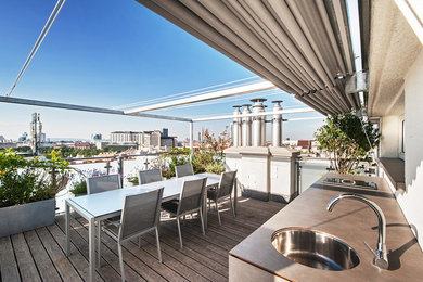This is an example of a contemporary roof rooftop terrace in Other with an outdoor kitchen and an awning.