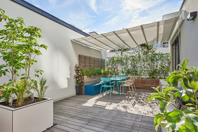 This is an example of a large contemporary roof terrace in Other with an outdoor kitchen and an awning.