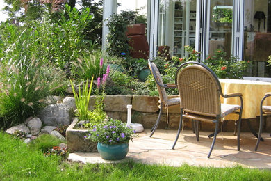 Diseño de terraza de estilo de casa de campo pequeña sin cubierta en patio trasero con jardín de macetas