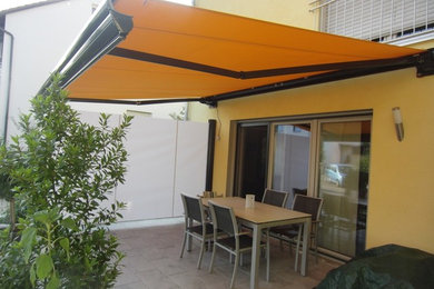 Immagine di una terrazza tradizionale di medie dimensioni con un parasole