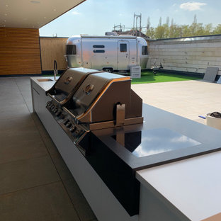 Large trendy courtyard outdoor kitchen deck photo in Berlin