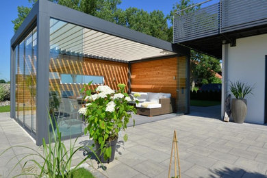 Mittelgroße Moderne Terrasse hinter dem Haus mit Kübelpflanzen in Sonstige