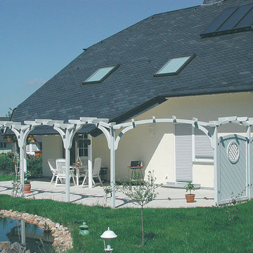 Terrasse mit Bogenpergola und Sichtschutz