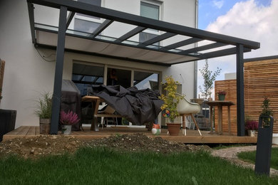 Ejemplo de terraza actual de tamaño medio en patio trasero y anexo de casas