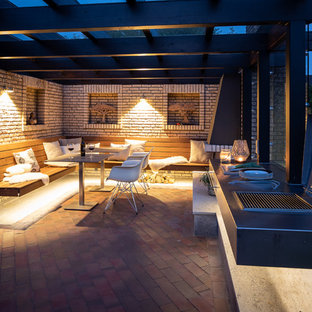 Große Moderne Terrasse hinter dem Haus mit Outdoor-Küche und Pergola in Bremen
