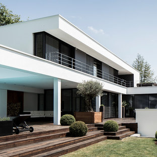 Große, Überdachte Moderne Terrasse hinter dem Haus mit Kübelpflanzen in München