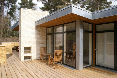 Foto de terraza minimalista en patio trasero y anexo de casas con brasero