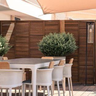 Exemple d'une terrasse tendance avec une terrasse en bois et un auvent.
