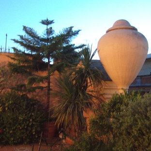 Esempio di un grande patio o portico chic davanti casa con un giardino in vaso, nessuna copertura e piastrelle