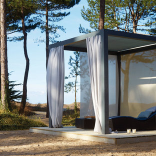 Cette image montre une terrasse arrière marine de taille moyenne avec une terrasse en bois et une pergola.