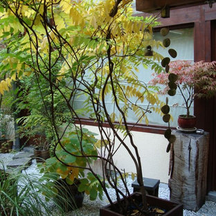 Ispirazione per un grande patio o portico etnico in cortile con ghiaia, un giardino in vaso e un tetto a sbalzo