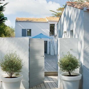 Cette image montre une terrasse avec des plantes en pots arrière marine de taille moyenne.
