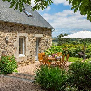 Exemple d'une terrasse arrière nature avec des pavés en brique et aucune couverture.
