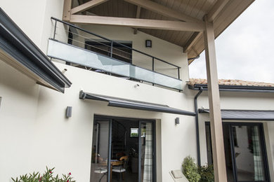 Idée de décoration pour une terrasse arrière champêtre de taille moyenne avec du carrelage et une extension de toiture.