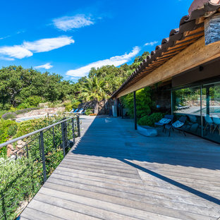 Exemple d'une très grande terrasse tendance avec une extension de toiture.