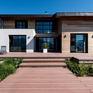 Cette image montre une terrasse arrière design avec une extension de toiture.