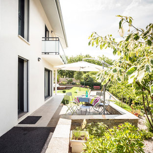 Cette image montre une terrasse latérale design de taille moyenne avec une terrasse en bois.