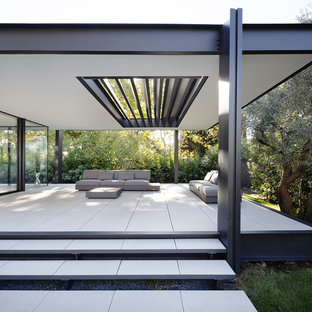 Idées déco pour une terrasse avant moderne de taille moyenne avec du carrelage et une extension de toiture.