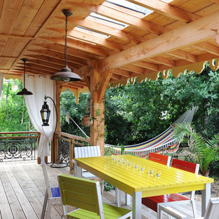 Inspiration pour une grande terrasse arrière bohème avec une extension de toiture.