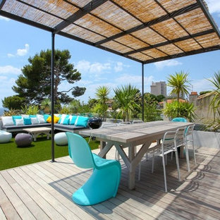 Exemple d'une terrasse sur le toit bord de mer avec une pergola.