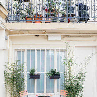 Ispirazione per un piccolo patio o portico industriale davanti casa con un giardino in vaso e piastrelle