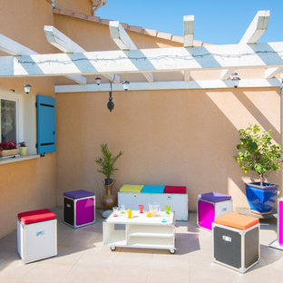 Exemple d'une terrasse avec des plantes en pots latérale éclectique de taille moyenne avec une pergola.