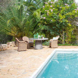 Aménagement d'une grande terrasse arrière exotique avec des pavés en brique et aucune couverture.