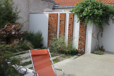Cette photo montre une petite terrasse avant moderne avec une dalle de béton.