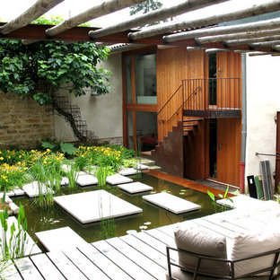 Idées déco pour une terrasse arrière éclectique de taille moyenne avec un point d'eau, une terrasse en bois et une pergola.