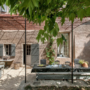 Esempio di un patio o portico country di medie dimensioni e dietro casa con una pergola