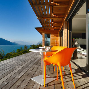 Cette photo montre une terrasse arrière tendance de taille moyenne avec une extension de toiture.