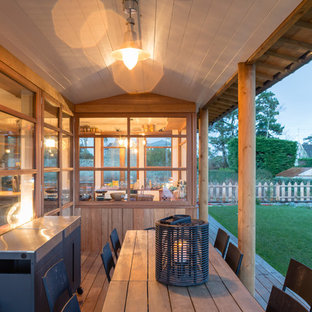 Inspiration pour une terrasse avec une cuisine extérieure arrière rustique de taille moyenne avec une extension de toiture.