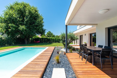 Cette photo montre une grande terrasse arrière tendance avec un auvent.