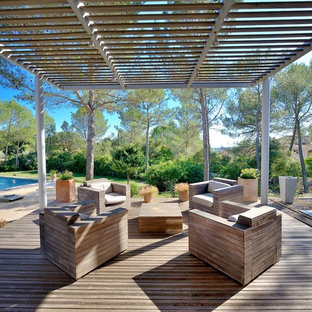 Exemple d'une terrasse arrière tendance avec une pergola.
