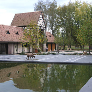 Réalisation d'une grande terrasse tradition avec un point d'eau, une cour, du carrelage et aucune couverture.