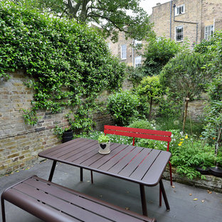 This is an example of a medium sized urban back terrace in Paris with a potted garden and no cover.