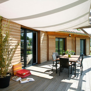 Inspiration pour une terrasse avec des plantes en pots arrière chalet de taille moyenne avec une pergola.